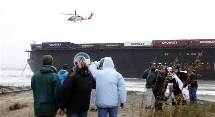 Severe Weather Barge AP Photo/Steve HelberA US Coast Guard helicopter prepares to lower two salvage crewmen onto a large barge that broke free is on the beach near the Sandbridge fishing pier in the Sandbridge area of Virginia Beach, Va., Friday, Nov. 13, 2009.