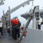 Sailors aboard USS Fitzgerald prepare to lower a rigid hull inflatable boat into the ocean to assist Japanese authorities with search and rescue and recovery operations.