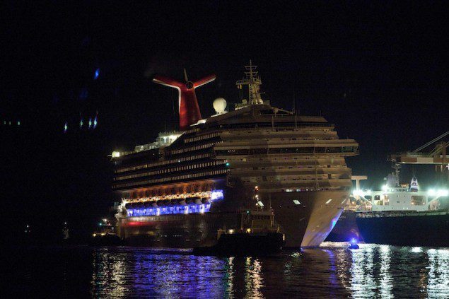 The Carnival Triumph cruise ship is towed towards dock at the port of Mobile