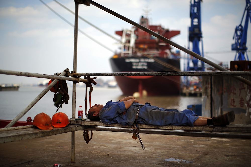 A labourer rests during a lunch break at the Hudong-Zhonghua Shipbuilding company's shipyard in Shanghai October 14, 2013.  REUTERS/Carlos Barria