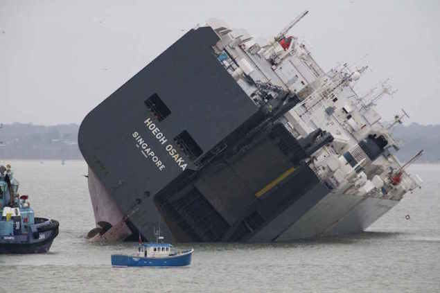 The cargo ship Hoegh Osaka lies on its side after being deliberately ran aground on the Bramble Bank in the Solent estuary, near Southampton in southern England January 5, 2015. REUTERS/Peter Nicholls