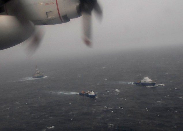 A Coast Guard HC-130 Hercules aircraft from Air Station Kodiak overflies the tugs Aiviq and Nanuq tandem towing the mobile drilling unit Kulluk 116 miles southwest of Kodiak City, Alaska, Sunday, Dec. 30, 2012. At the time of the photo, the tug Alert from Prince William Sound and the Coast Guard Cutter Alex Haley from Kodiak were en route to assist. U.S. Coast Guard photo by Petty Officer 3rd Class Chris Usher.