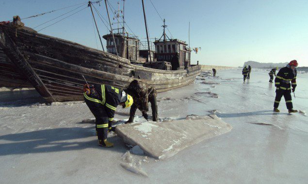 Investigators inspect a port where ships are stranded in ice, in Jinzhou, Liaoning province, January 5, 2013. (c) REUTERS/China Daily