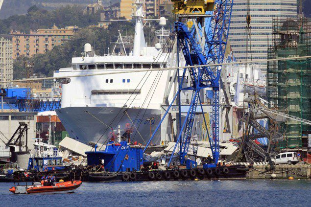 A crane barge is pictured in front of the debris of the collapsed control tower of the port in Genoa May 8, 2013.  Image (c) REUTERS/Alessandro Garofalo