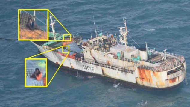 Suspected pirates on board the FV Naham 3 point their weapons at an EUNAVFOR helicopter. Photo: EUNAVFOR