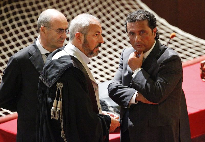 Francesco Schettino (R), captain of the Costa Concordia cruise ship, talks with his lawyers during a trial in Grosseto, central Italy, July 17, 2013.