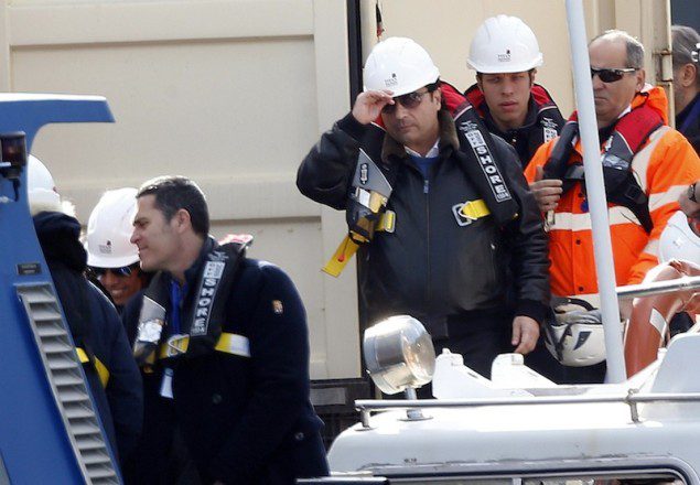Schettino, the captain of the Costa Concordia, adjusts his helmet as he waits to board the cruise liner at Giglio harbour