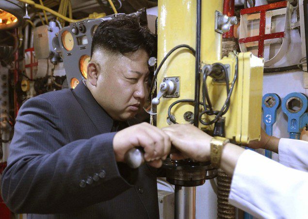 North Korean leader Kim Jong Un looks through a periscope of a submarine during his inspection of the KPA Naval Unit 167