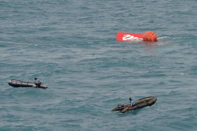Part of the tail of AirAsia QZ8501 floats on the surface after being lifted as Indonesian navy divers conduct search operations for the black box flight recorders and passengers and crew of the aircraft, in the Java Sea January 10, 2015. REUTERS/Adek Berry/Pool