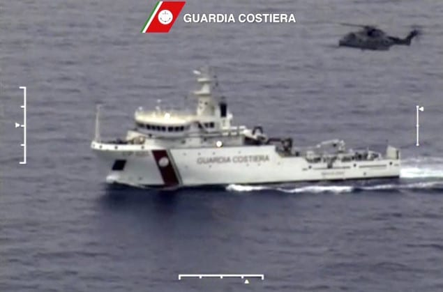 An Italian coast guard vessel is seen with an helicopter during the search and rescue operation underway after a boat carrying migrants capsized overnight, with up to 700 feared dead, in this still image taken from video April 19, 2015.