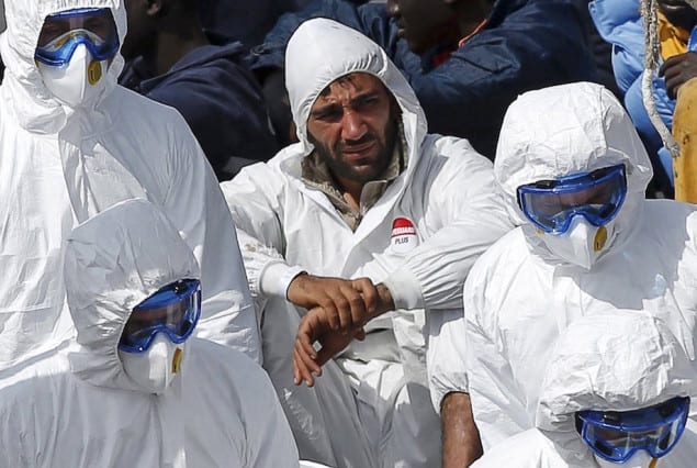 Mohammed Ali Malek (C, rear), one of two survivors of Saturday's migrant boat disaster, later arrested on suspicion of people trafficking, is seen watching bodies of dead migrants being disembarked from the Italian coastguard ship Bruno Gregoretti, at Senglea in Valletta's Grand Harbour April 20, 2015. REUTERS/Darrin Zammit Lupi