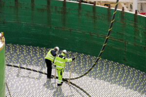 Workers guide the loading of miles of subsea power cables onto the spool of Skagerrak.  Image courtesy of Nexans
