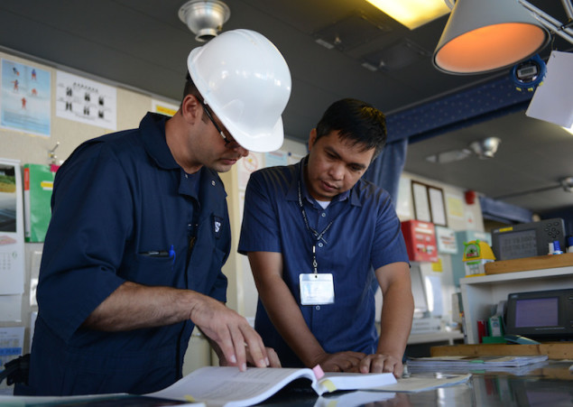Lt.j.g. Nathan Clinger, a port state control officer at Coast Guard Sector Honolulu Prevention, checks a manual with the ship’s captain aboard the 600-foot Panamanian flagged bulk freight ship, Teizan, at Kalaeloa Barbers Point Harbor, May 19, 2015. Coast Guard crew members conduct inspections to ensure a vessel has a suitable structure, correct documentation, proper working equipment and lifesaving equipment and adequate accommodations. (U.S. Coast Guard photo by Petty Officer 2nd Class Tara Molle)