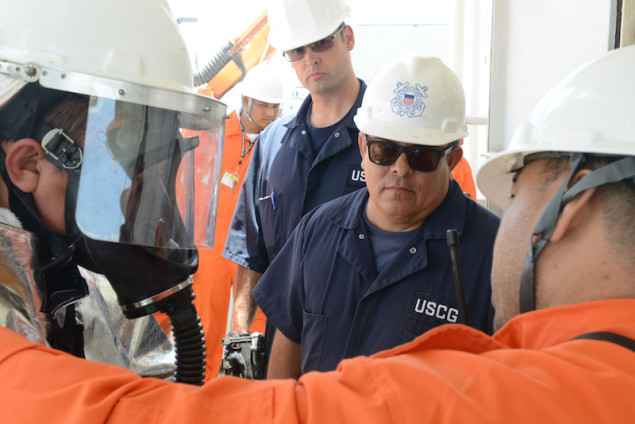 Tim Wilcox and Lt. j.g. Nathan Clinger, port state control officers at Coast Guard Sector Honolulu Prevention, observe crew members preparing to conduct a firefighting drill aboard the 600-foot Panamanian-flagged bulk freight ship Teizan, at Kalaeloa Barbers Point Harbor, May 19, 2015. Coast Guard crew members conduct inspections to ensure a vessel has a suitable structure, correct documentation, proper working equipment and lifesaving equipment, and adequate accommodations. (U.S. Coast Guard photo by Petty Officer 2nd Class Tara Molle)