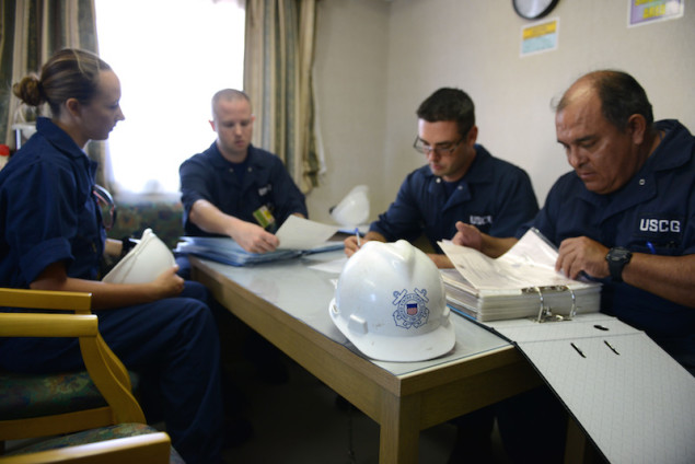 Crew members from Coast Guard Sector Honolulu Prevention examine documentation aboard the 600-foot Panamanian flagged bulk freight ship, Teizan, at Kalaeloa Barbers Point Harbor, May 19, 2015. Coast Guard crew members conduct inspections to ensure a vessel has a suitable structure, correct documentation, proper working equipment and lifesaving equipment and adequate accommodations. (U.S. Coast Guard photo by Petty Officer 2nd Class Tara Molle)