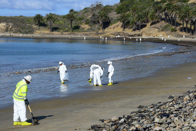 Beach cleanup crew members work to cleanup oil from the beach at Refugio State Beach, Calif., May 22, 2015. The oil spilled into the Pacific Ocean from a broken on-land pipeline impacted the coasts and maritime environment north of Santa Barbara.U.S Coast Guard Photo