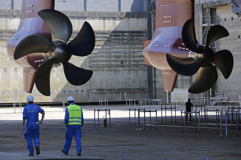 Ship builders walk near propellers of the Harmony of the Seas ( Oasis 3 ) class ship at the STX Les Chantiers de l'Atlantique shipyard site in Saint-Nazaire, France, June 17, 2015. REUTERS/Stephane Mahe