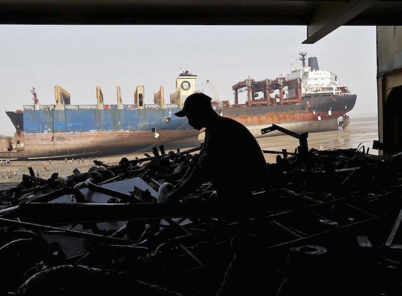 A worker sorts out the engine parts of a decommissioned ship as he dismantles it at the Alang shipyard in Gujarat, India, in this March 27, 2015 file photo. REUTERS/Amit Dave/Files