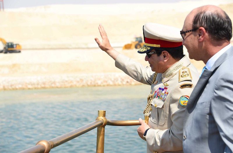 Egyptian President Abdel Fattah al-Sisi (L) and Mohab Mameesh, chairman of the Suez Canal Authority, stand in a boat inside the Suez Canal as they attend the celebration, August 6, 2015. REUTERS/The Egyptian Presidency/Handout
