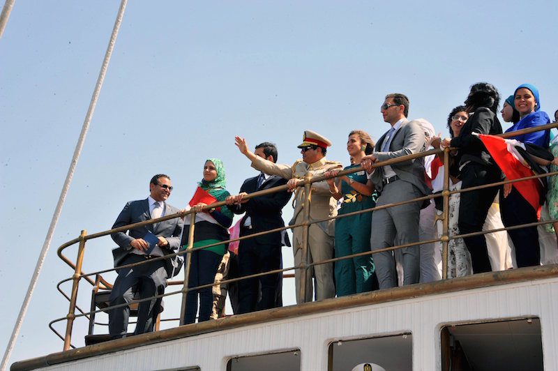 Egyptian President Abdel Fattah al-Sisi waves from a boat on the Suez Canal, August 6, 2015. REUTERS/The Egyptian Presidency/Handout