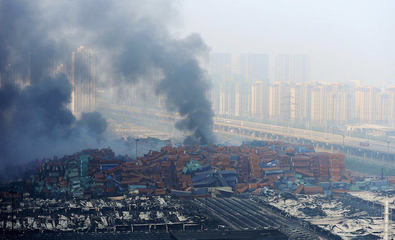 Smoke rises from shipping containers after explosions at Binhai new district in Tianjin, China, August 13, 2015. REUTERS/Stringer