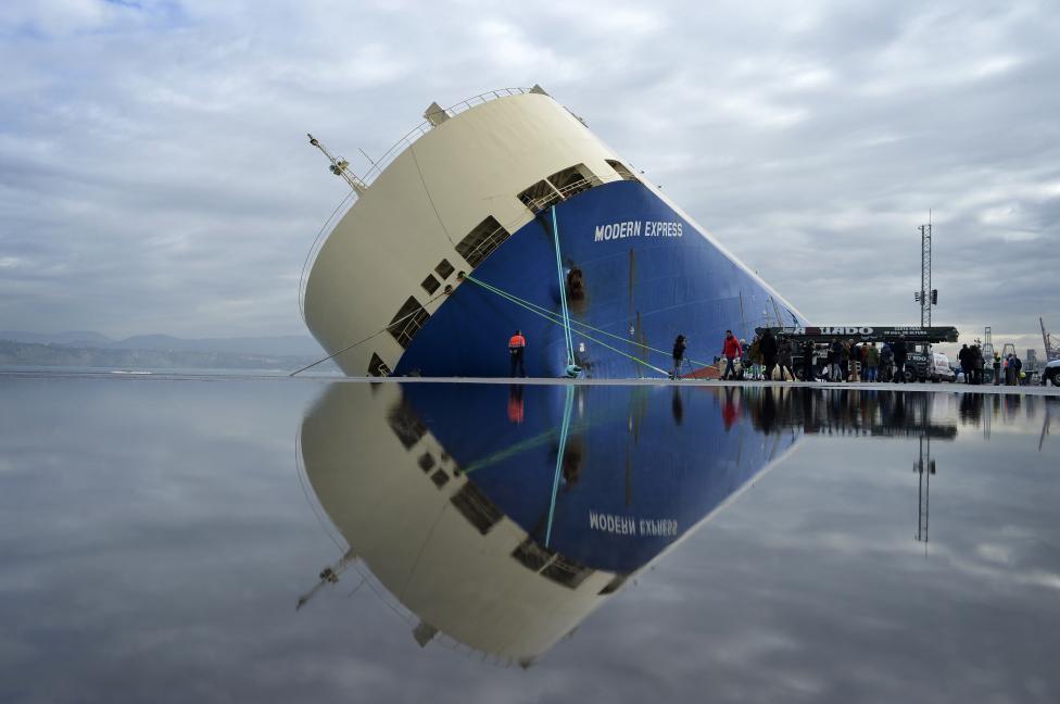 The cargo ship Modern Express is reflected in water on the dock as it lists at a mooring in the port of Bilbao