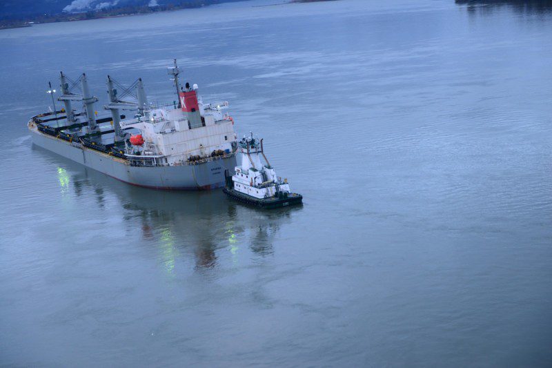 The motor vessel Sparna, a 623-foot Panamanian-flagged bulk carrier, lists to its port side after taking on water in void spaces after reportedly running aground while transiting the Columbia River near Cathlamet, Wash., March 21, 2016. The vessel is safely anchored and the Coast Guard is monitoring the situation until repairs can be made. (U.S. Coast Guard photo by Petty Officer 1st Class Levi Read)