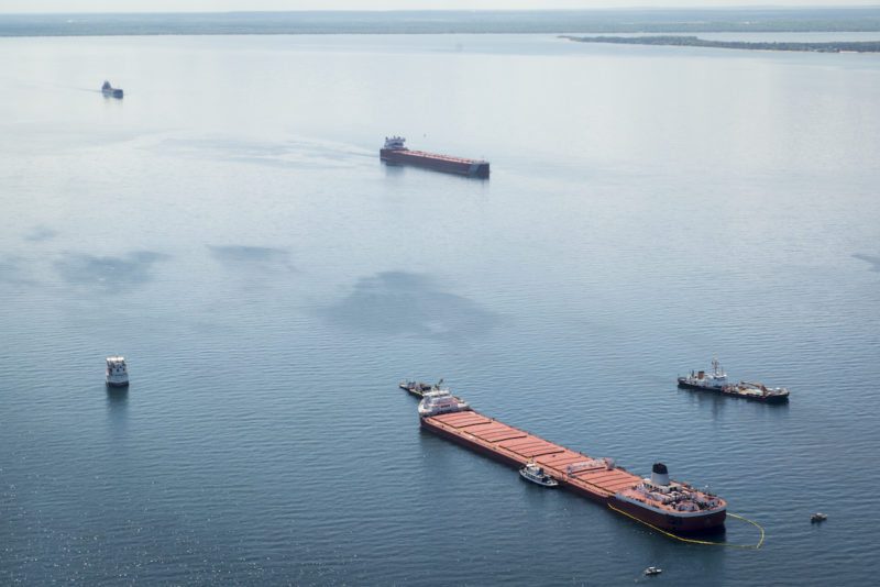 Two freighters transit upbound the Soo Locks past the safety zone established by the U.S. Coast Guard around the motor vessel Roger Blough near Gros Reefs Light, May 30, 2016 in Lake Superior. The safety zone was established after the Blough ran aground on the reef May 27. (U.S. Coast Guard photo by Petty Officer 2nd Class Christopher M. Yaw)