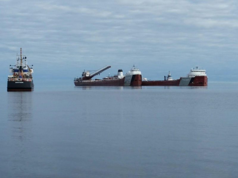 The motor vessel Phillip R. Clarke arrives on scene with the motor vessel Roger Blough that ran aground on May 27, near Gros Cap Reefs Light in Lake Superior, June 3, 2016. The Clarke is scheduled to remove some of the taconite from the Blough in order to lighten the Blough so it can be refloated, and the U.S. Coast Guard Cutter Buckthorn is on scene to enforce the 750-yard safety zone around the ships. (U.S. Coast Guard photo by Craig Gorman)