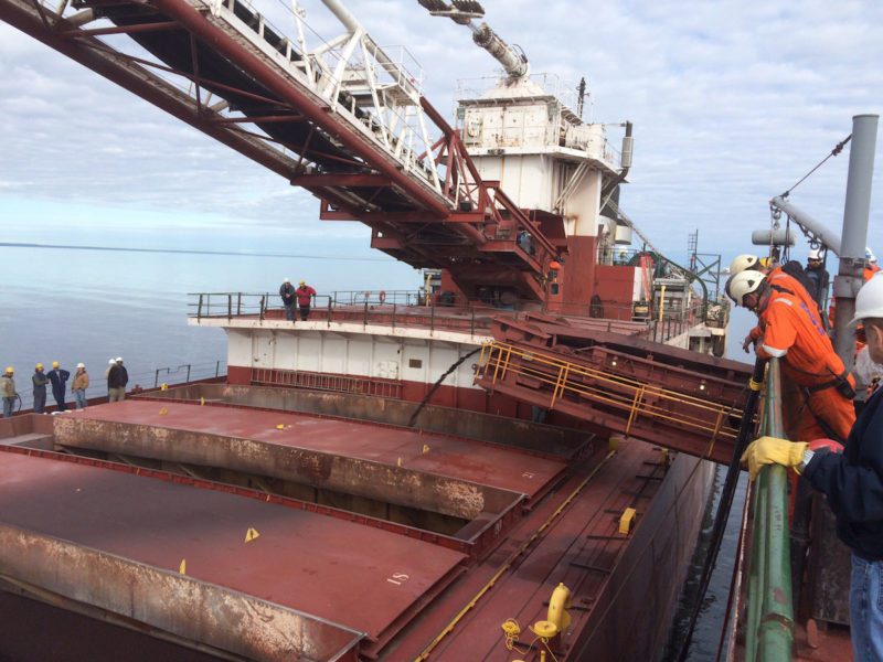 The motor vessel Phillip R. Clarke receives taconite by conveyor belt from the motor vessel Roger Blough that ran aground on May 27, near Gros Cap Reefs Light in Lake Superior, June 3, 2016. The Clarke is scheduled to remove some of the taconite from the Blough in order to lighten the Blough so it can be refloated. (U.S. Coast Guard photo by Petty Officer 2nd Class Kyle Schmidt)