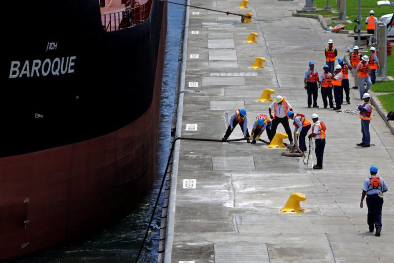 Workers pull the rope during the first trial run of a Post-Panamax cargo ship in the new sets of locks on the Atlantic side of the Panama Canal, in Panama City, Panama June 9, 2016. REUTERS/Carlos Jasso