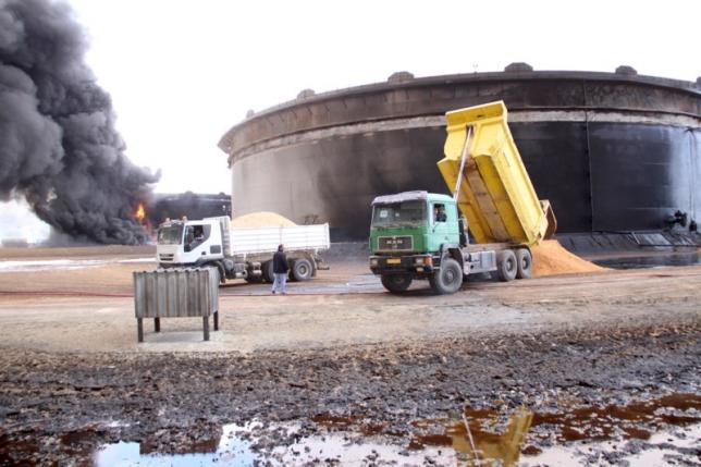 File photo of smoke rising from burning oil storage tanks in the port of Ras Lanuf, Libya