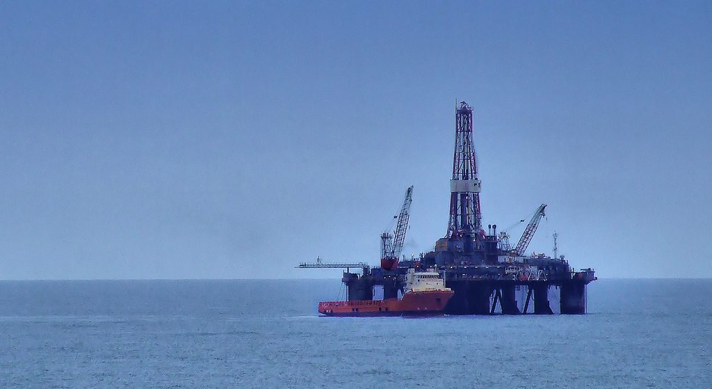 north sea oil rig with offshore workboat alongside