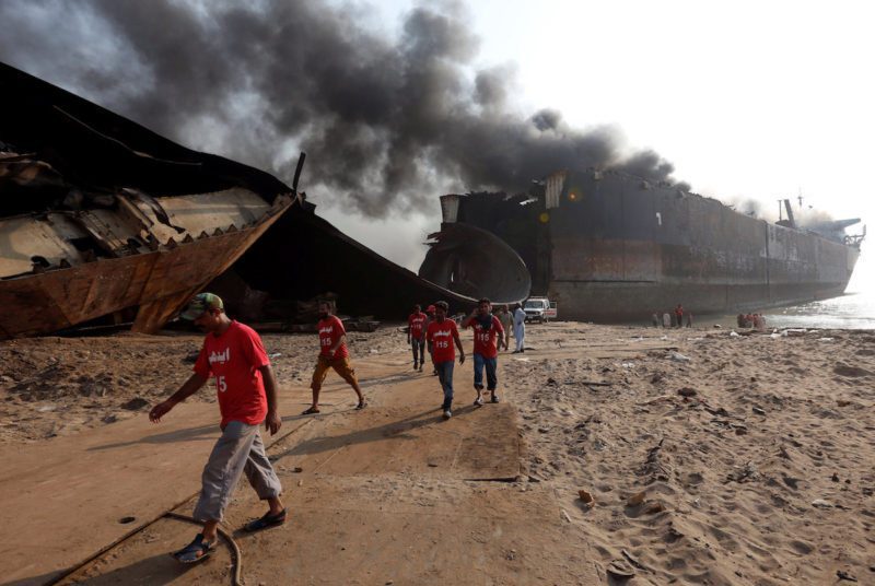 Rescue workers walk near the burning oil tanker at the ship-breaking yard in Gaddani, Pakistan, November 2, 2016. REUTERS/Akhtar Soomro