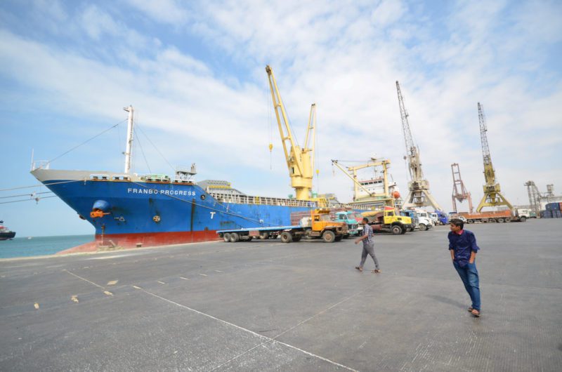 FILE PHOTO - People walk past a ship docked at the Red Sea port of Hodeidah, Yemen February 1, 2017. REUTERS/Abduljabbar Zeyad/Files