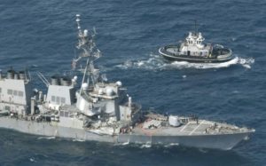 The Arleigh Burke-class guided-missile destroyer USS Fitzgerald, damaged by colliding with a Philippine-flagged merchant vessel, is seen next to a tugboat off Shimoda, Japan