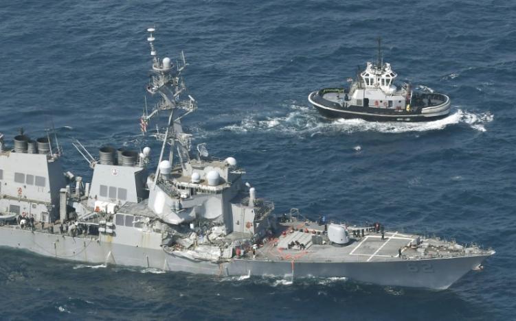 The Arleigh Burke-class guided-missile destroyer USS Fitzgerald, damaged by colliding with a Philippine-flagged merchant vessel, is seen next to a tugboat off Shimoda, Japan