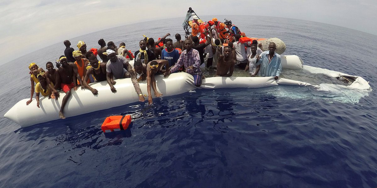 FILE PHOTO: Migrants on a dinghy are rescued by "Save the Children" NGO crew from the ship Vos Hestia in the Mediterranean sea off Libya coast