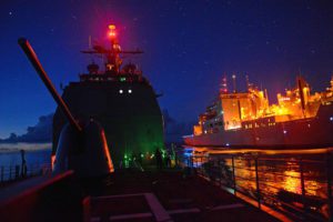 US Navy guided missile cruiser underway at night
