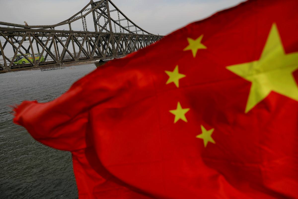 A Chinese flag is seen in front of the Friendship bridge over the Yalu River connecting the North Korean town of Sinuiju and Dandong in China