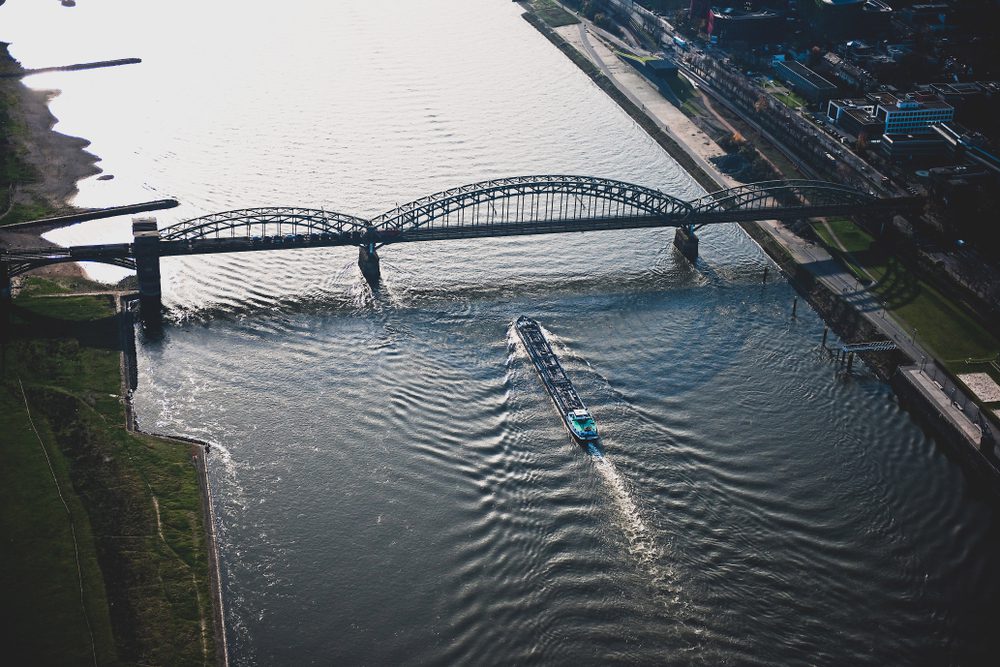 a ship passes below a bridge on the Rhine River