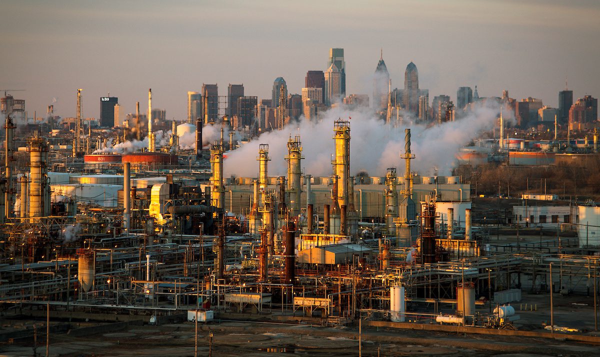 The Philadelphia Energy Solutions oil refinery is seen at sunset in front of the Philadelphia skyline