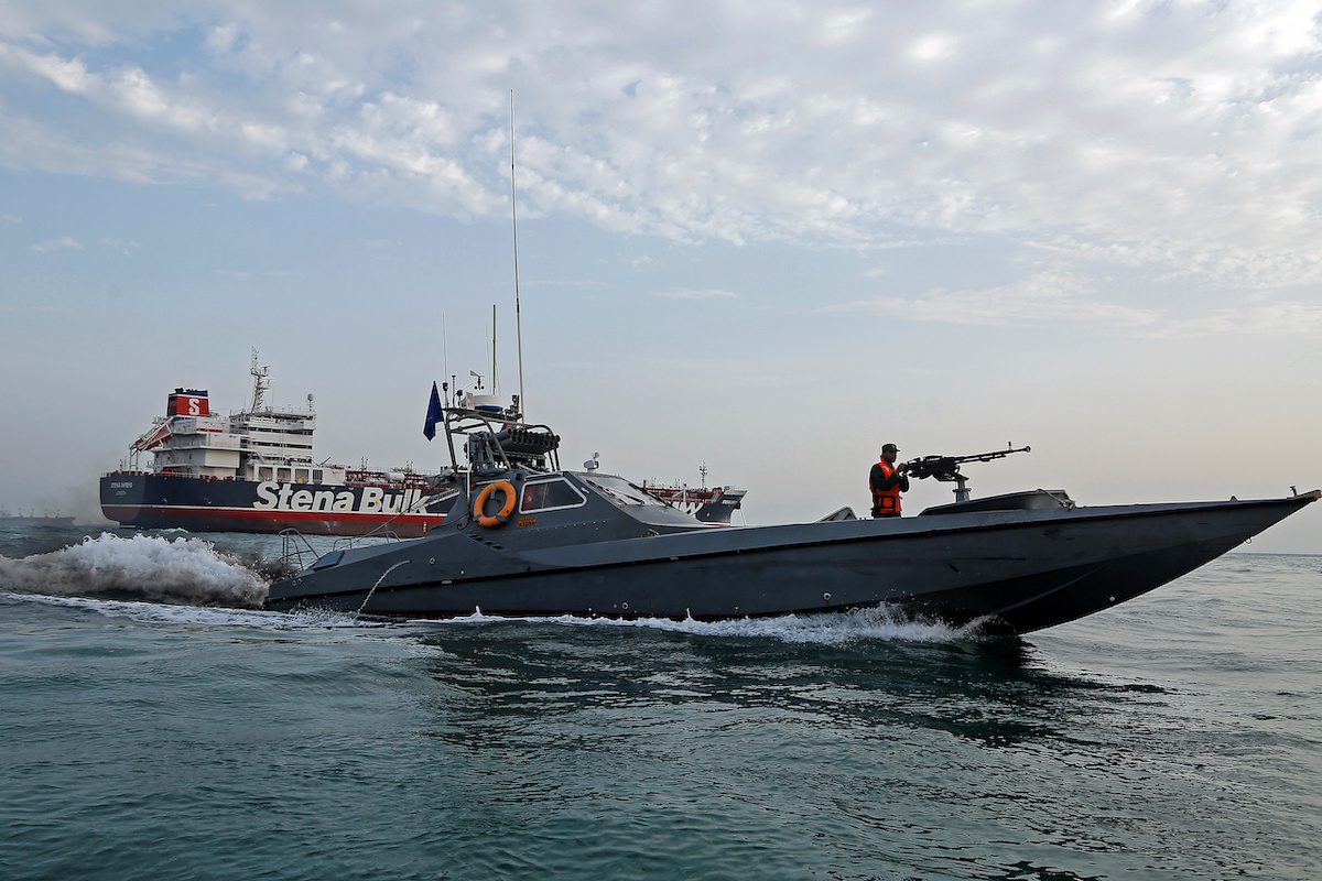 A boat of the Iranian Revolutionary Guard sails next to Stena Impero at Bandar Abbas port