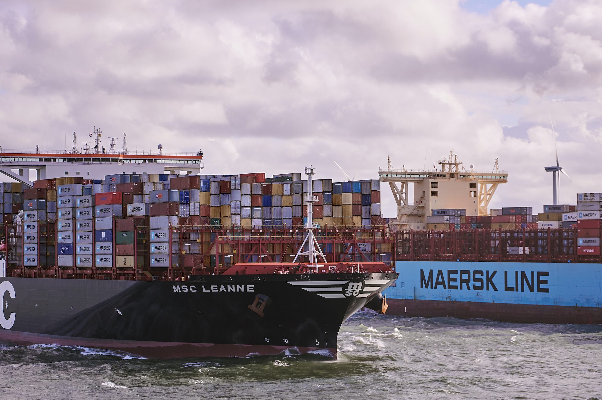 An MSC containership passes a Maersk containership