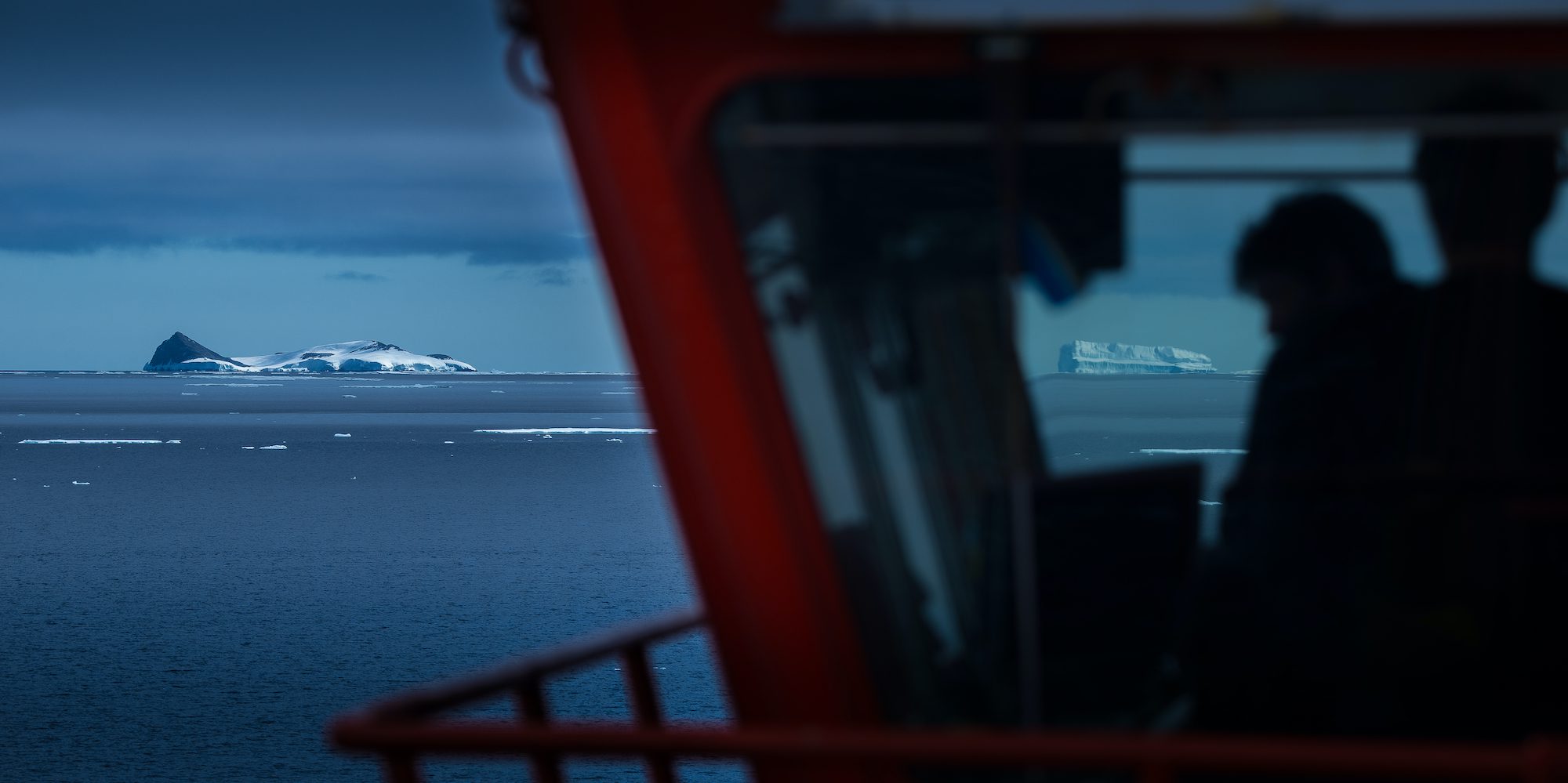 Ships bridge silhouetted with Antarctic Icebergs on the Horizon