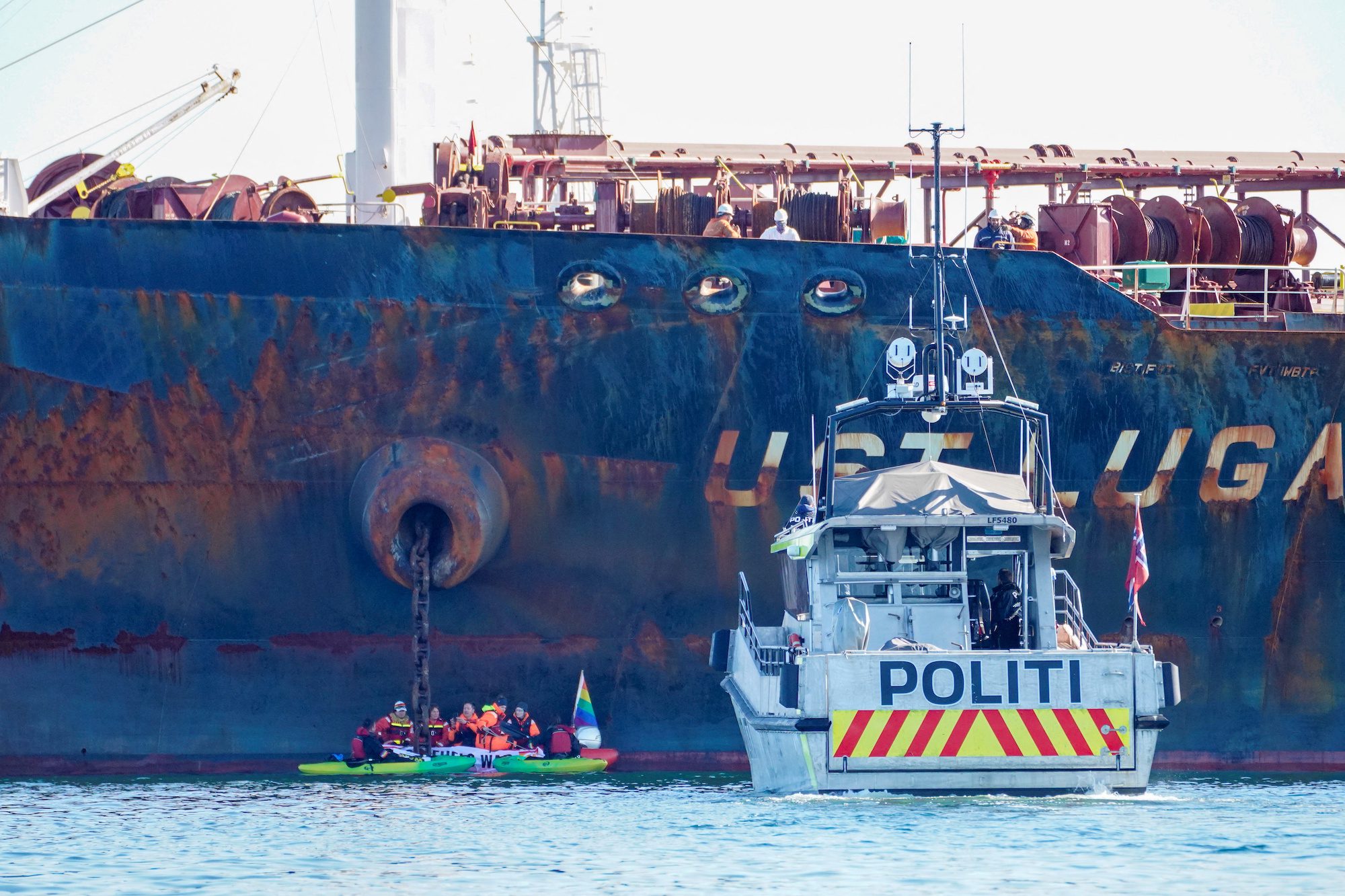 A police vessel sails near members of Greenpeace blocking a tanker "Ust Luga" from delivering Russian oil to Norway as part of a protest against the Russia's invasion of Ukraine.
