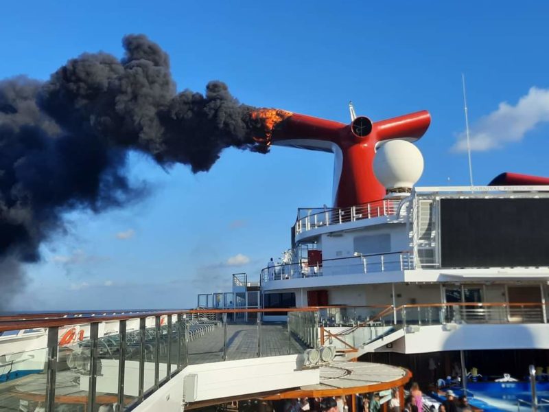 flames and smoke come from the funnel onboard the Carnival Freedom cruise ship