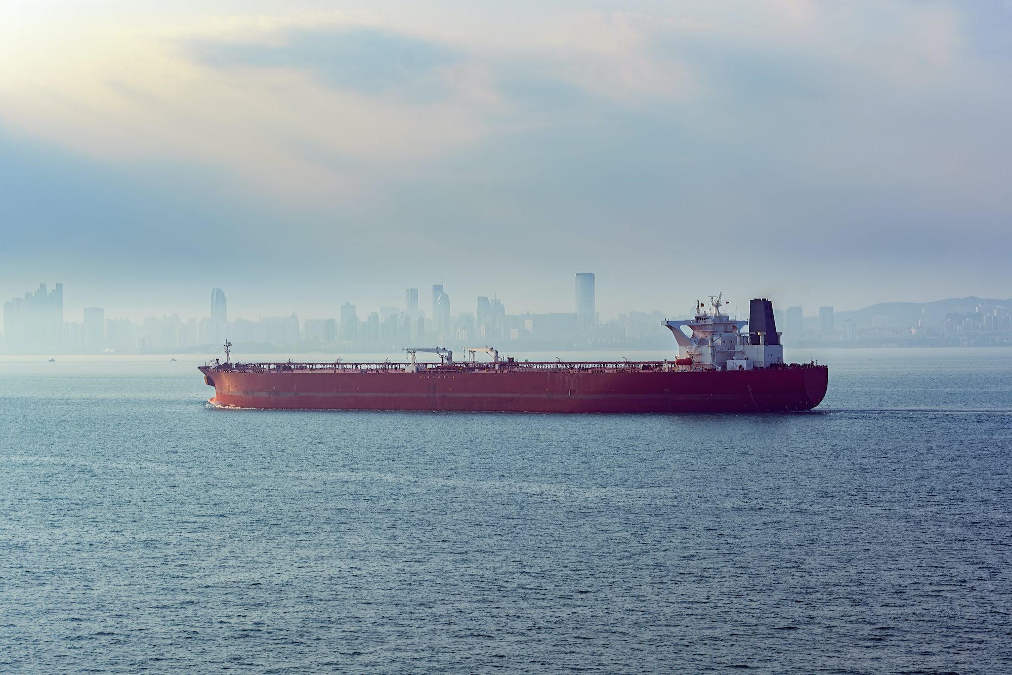 Laden crude oil tanker approaches the port of Qingdao, China in the morning fog. Photo credit: Shutterstock/Igor Grochev