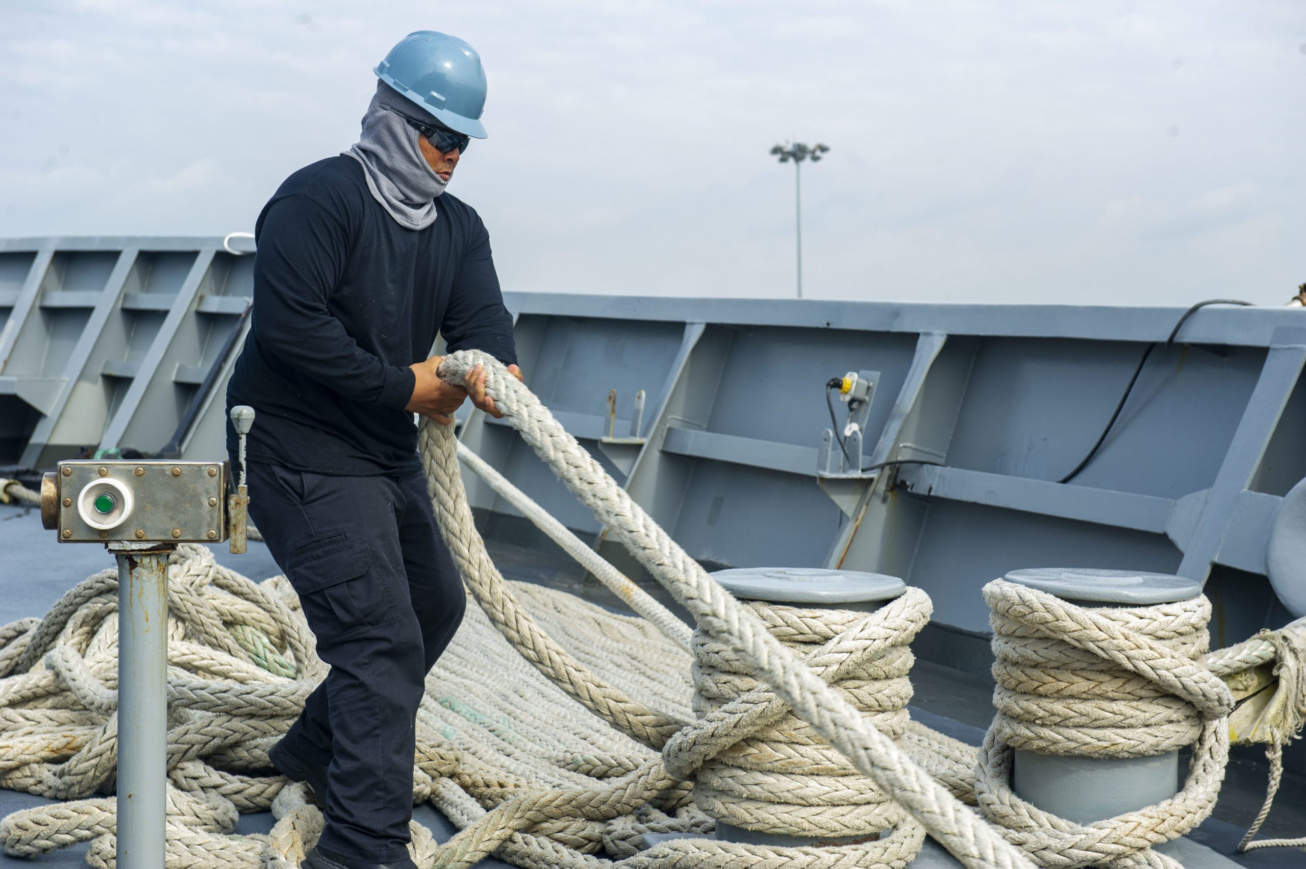 US Merchant Mariner handling lines on the bow of an American flagged ship