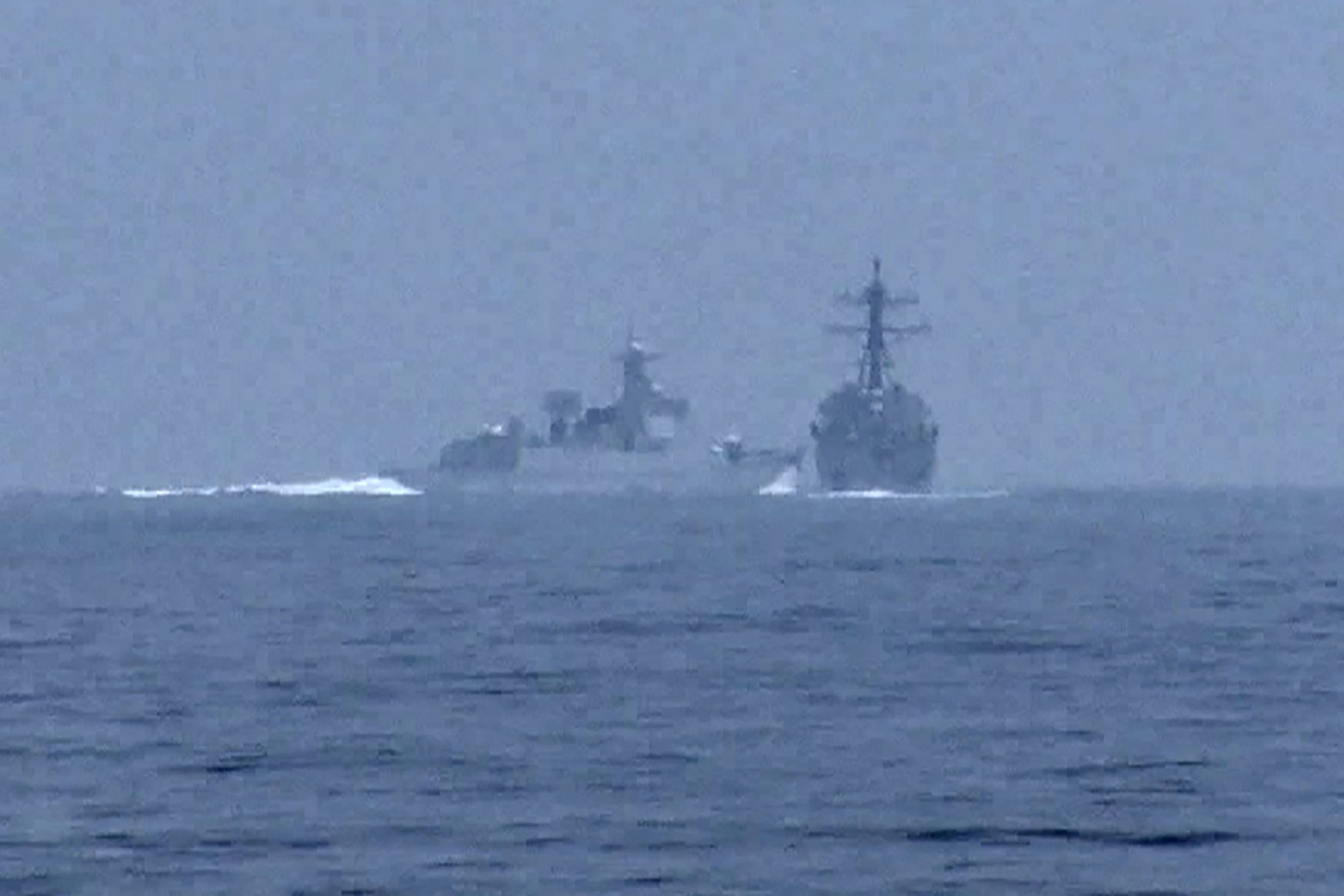 A People's Republic of China (PRC) warship, identified by the U.S. Indo-Pacific Command as PRC LY 132, crosses the path of U.S. Navy destroyer USS Chung-Hoon as it was transiting the Taiwan Strait with the Royal Canadian Navy frigate HMCS Montreal June 3, 2023, in a still image from video. Photo via Global News via REUTERS.